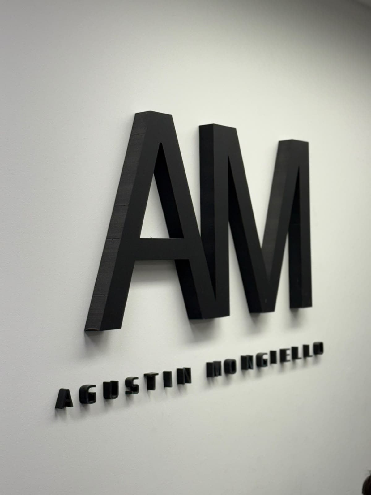 Logo AM en la pared del salón de AM Barbería